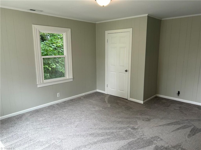 unfurnished bedroom with ornamental molding, dark colored carpet, and a closet