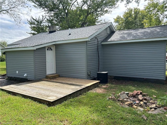 rear view of property featuring a wooden deck, a lawn, and central air condition unit