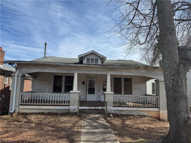 bungalow-style home featuring a porch and brick siding