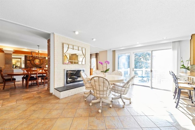 dining area featuring a fireplace, light tile patterned floors, and a textured ceiling