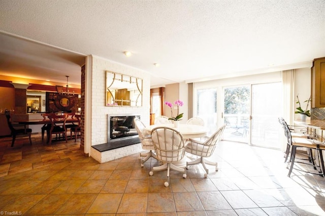 dining space featuring a fireplace, a textured ceiling, and tile patterned floors