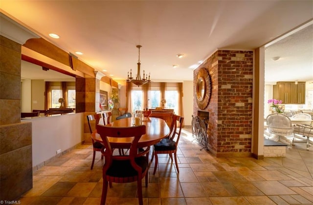 dining room featuring a fireplace and an inviting chandelier