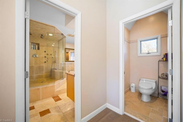 bathroom with vanity, toilet, and a shower with door