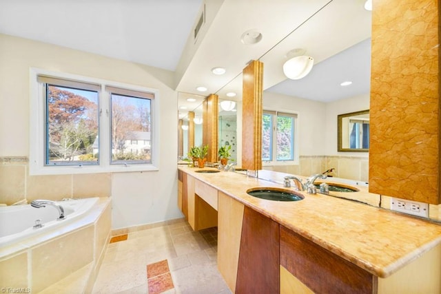 bathroom featuring vanity and tiled tub