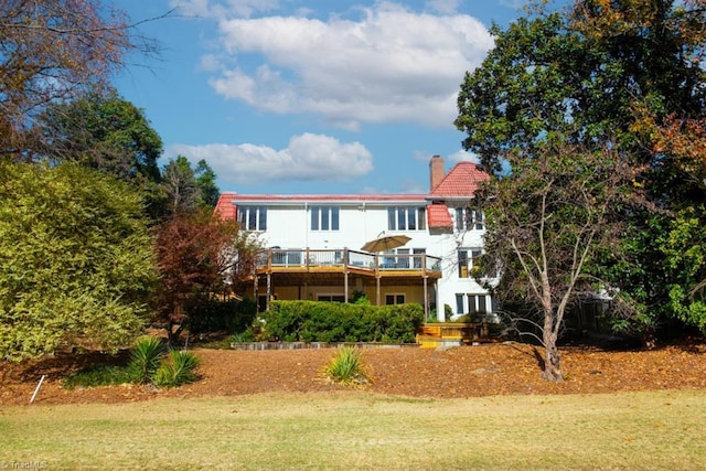 rear view of house with a yard and a wooden deck