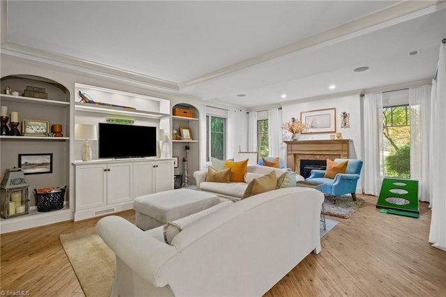 living room featuring ornamental molding and light hardwood / wood-style floors