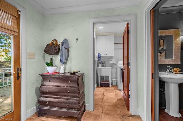 hallway featuring crown molding, sink, and light tile patterned floors