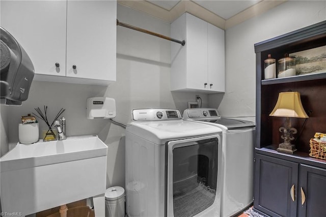 washroom featuring sink, separate washer and dryer, and cabinets