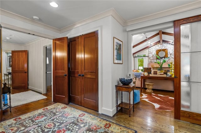 foyer featuring vaulted ceiling with beams, ornamental molding, and dark hardwood / wood-style flooring