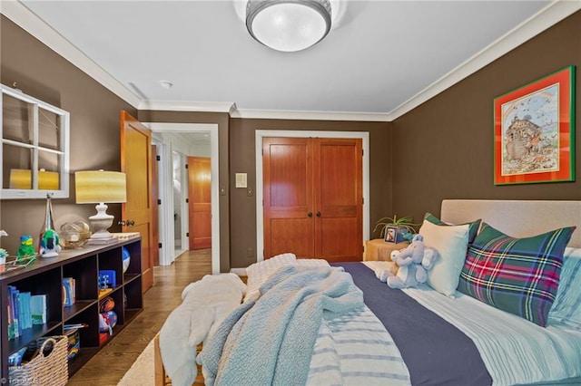 bedroom featuring a closet, ornamental molding, and hardwood / wood-style floors