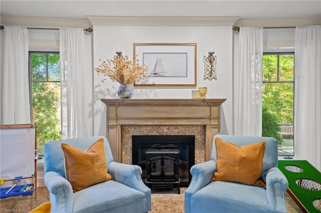 sitting room with crown molding and a high end fireplace