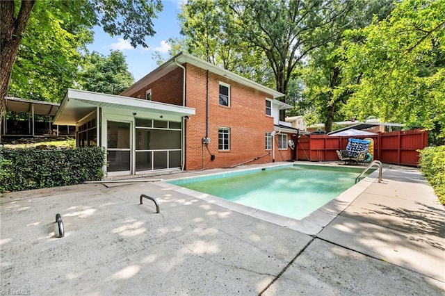 view of pool featuring a patio area and a sunroom