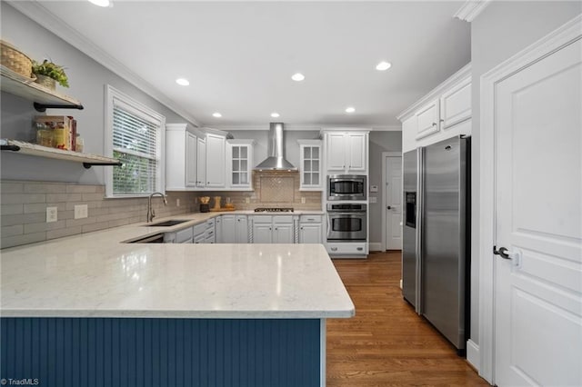 4803 Bluff Run Dr, Greensboro, NC 27455 - kitchen featuring stainless steel appliances, a sink, wall chimney range hood, a peninsula, and crown molding