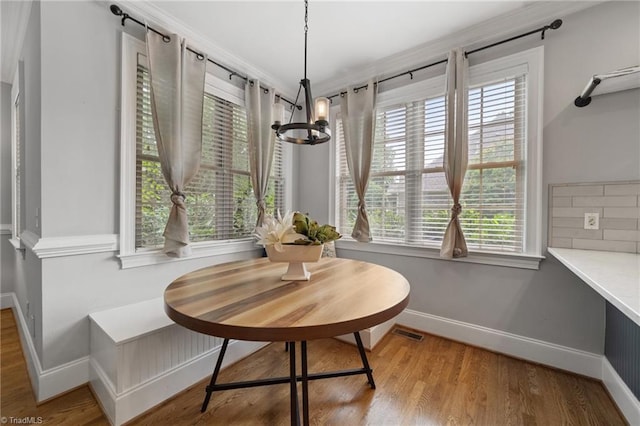 4803 Bluff Run Dr, Greensboro, NC 27455 - dining area featuring a chandelier, baseboards, wood finished floors, and crown molding