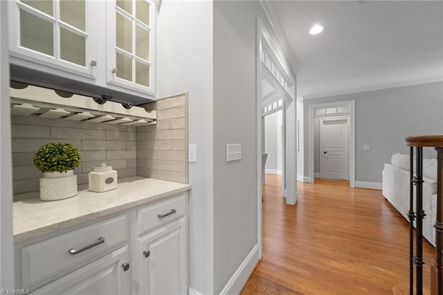 4803 Bluff Run Dr, Greensboro, NC 27455 - bar area featuring backsplash, ornamental molding, baseboards, and light wood-style flooring
