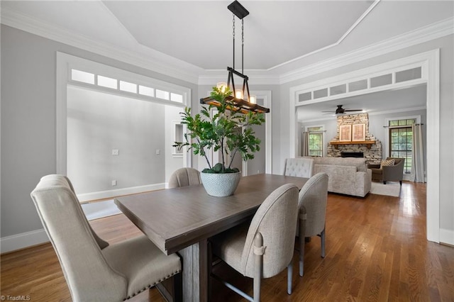 4803 Bluff Run Dr, Greensboro, NC 27455 - dining space featuring a stone fireplace, ceiling fan, wood finished floors, baseboards, and ornamental molding