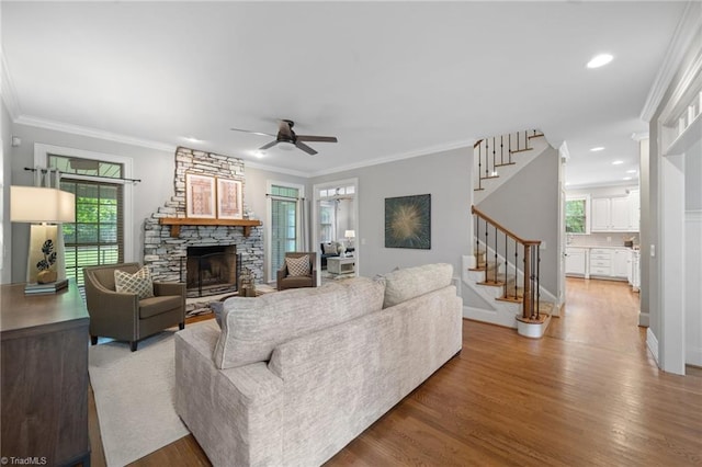4803 Bluff Run Dr, Greensboro, NC 27455 - living room with stairs, a stone fireplace, a ceiling fan, wood finished floors, and crown molding