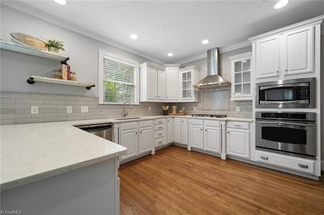4803 Bluff Run Dr, Greensboro, NC 27455 - kitchen featuring appliances with stainless steel finishes, wall chimney exhaust hood, a sink, crown molding, and white cabinetry