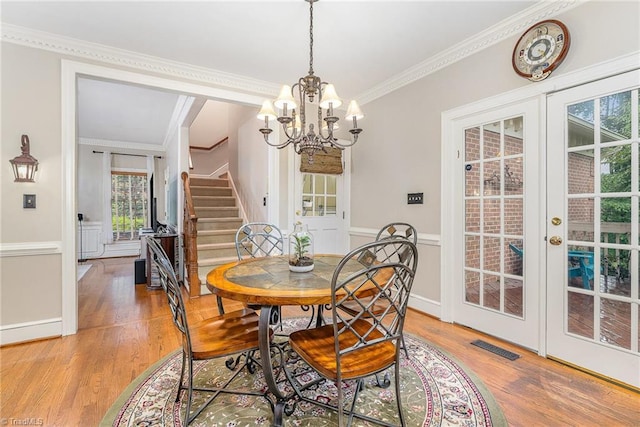 5002 Leadenhall Rd, Oak Ridge, NC 27310 - dining area featuring light wood-type flooring, french doors, ornamental molding, stairway, and a chandelier
