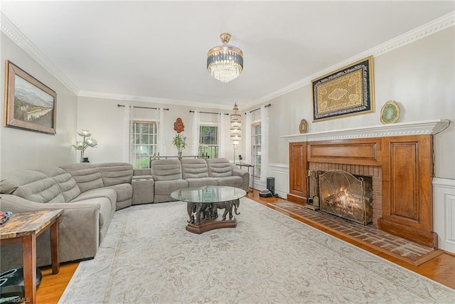 5002 Leadenhall Rd, Oak Ridge, NC 27310 - living area with a fireplace, light wood finished floors, ornamental molding, a chandelier, and wainscoting