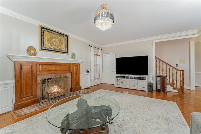 5002 Leadenhall Rd, Oak Ridge, NC 27310 - living area with stairs, ornamental molding, wood finished floors, a chandelier, and a brick fireplace