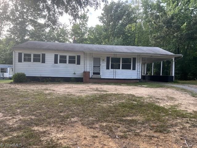 single story home featuring covered porch, a front yard, and a carport