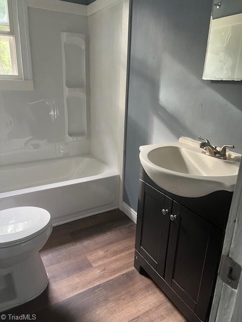 full bathroom featuring vanity, toilet, wood-type flooring, and bathtub / shower combination