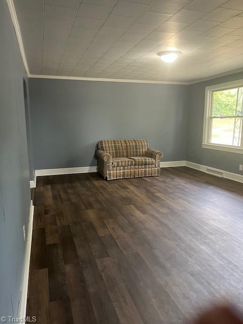 unfurnished room with dark hardwood / wood-style floors and crown molding