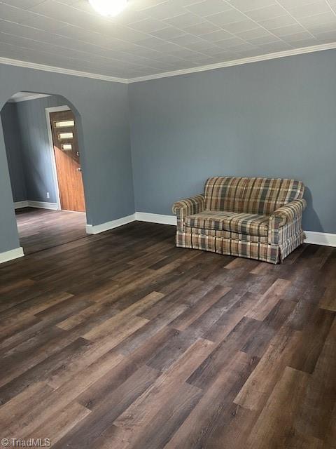 living area with dark hardwood / wood-style flooring and ornamental molding