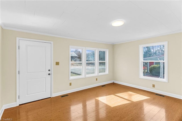 spare room featuring visible vents, baseboards, and wood finished floors