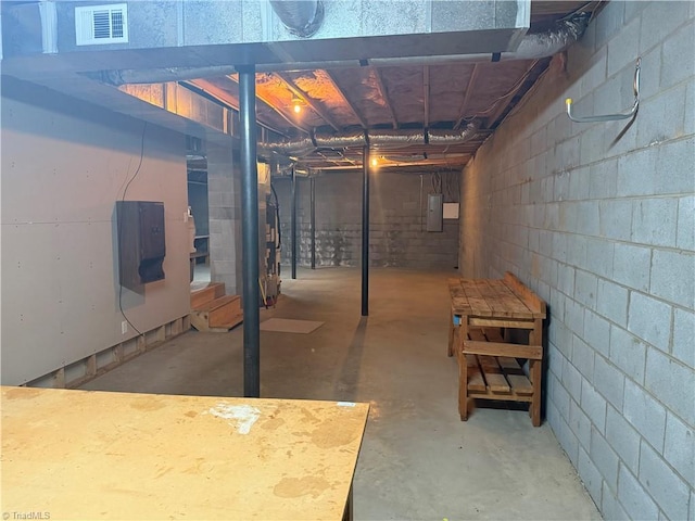 unfinished basement featuring electric panel and visible vents