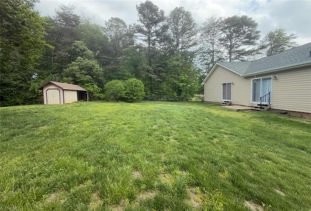 view of yard featuring an outdoor structure, entry steps, and a storage unit