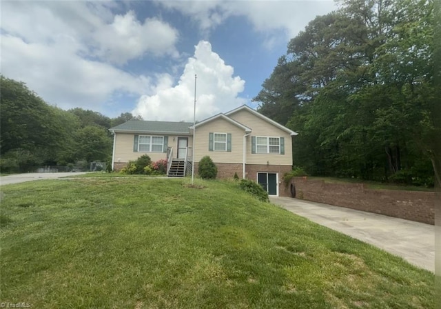 ranch-style home with concrete driveway and a front lawn