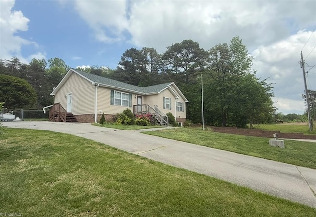 view of front of house with concrete driveway and a front yard
