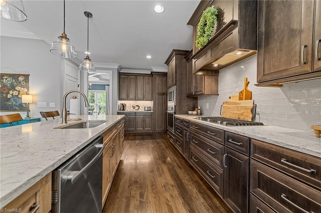 7823 Gatsby Pl, Greensboro, NC 27455 - kitchen with appliances with stainless steel finishes, dark wood finished floors, custom exhaust hood, light stone countertops, and decorative light fixtures