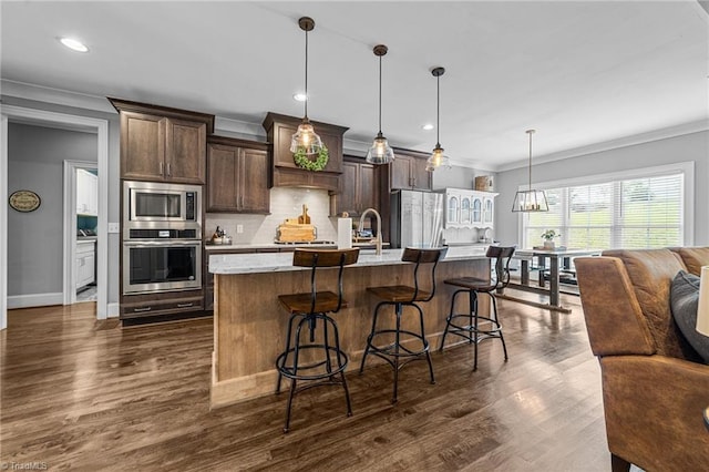 7823 Gatsby Pl, Greensboro, NC 27455 - kitchen with stainless steel appliances, tasteful backsplash, crown molding, dark brown cabinetry, and dark wood finished floors