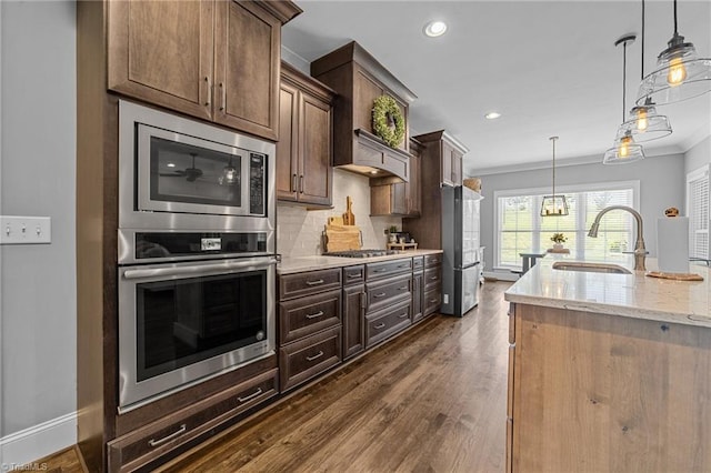 7823 Gatsby Pl, Greensboro, NC 27455 - kitchen featuring appliances with stainless steel finishes, dark wood-style floors, ornamental molding, light stone counters, and recessed lighting