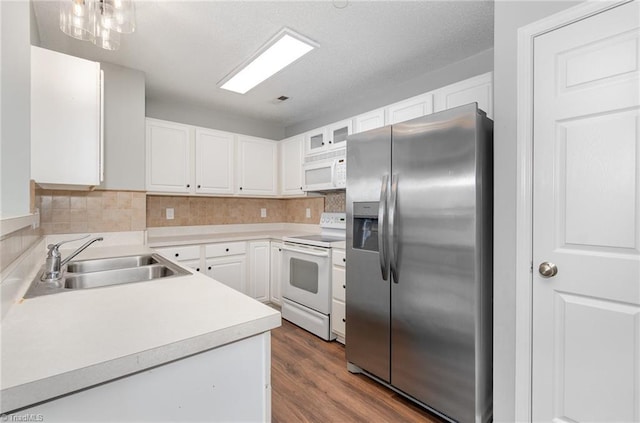 kitchen featuring white appliances, white cabinetry, light countertops, and a sink