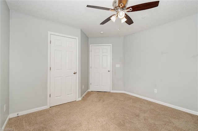 unfurnished bedroom with light carpet, baseboards, and a textured ceiling