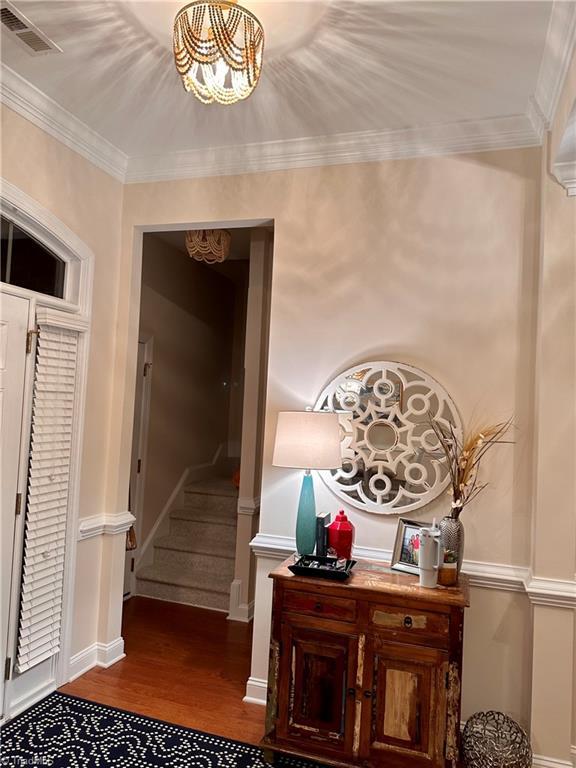 corridor with hardwood / wood-style floors and crown molding