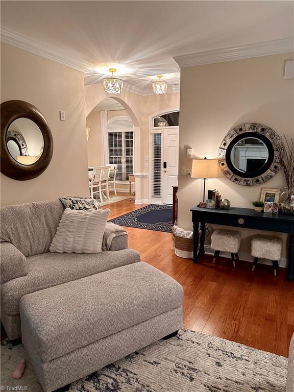 living room with wood-type flooring and ornamental molding