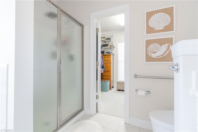 bathroom featuring tile patterned floors, toilet, and walk in shower