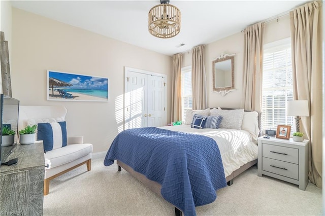 carpeted bedroom with a chandelier