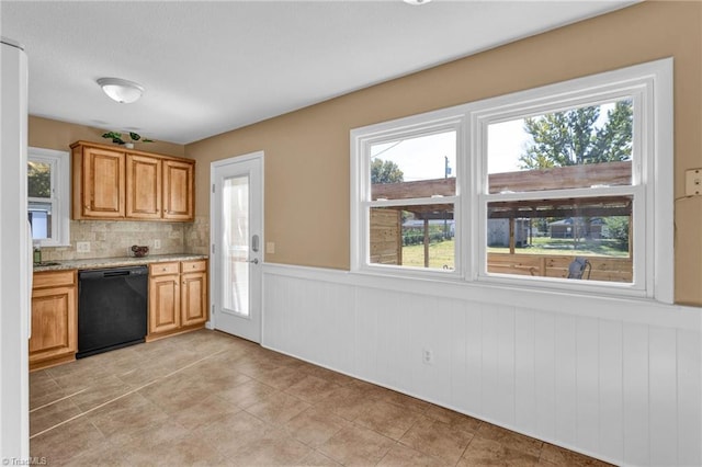 kitchen with backsplash, light tile patterned flooring, light stone countertops, and dishwasher