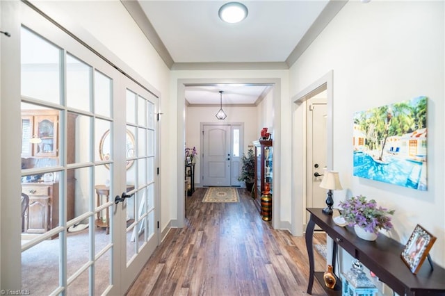 interior space featuring french doors, crown molding, baseboards, and wood finished floors