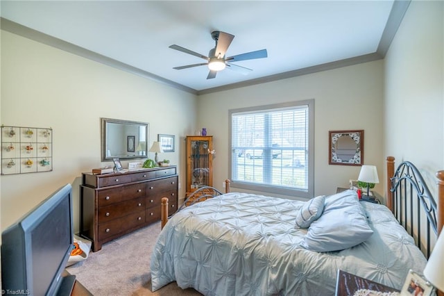 bedroom featuring light colored carpet, crown molding, and ceiling fan