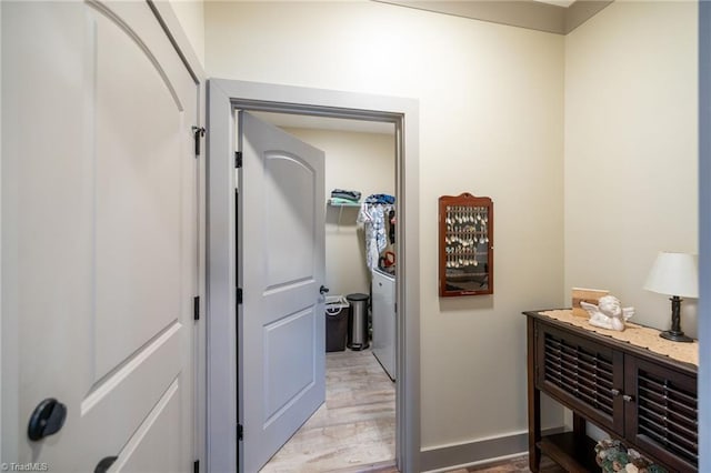 hall featuring light wood-type flooring and baseboards