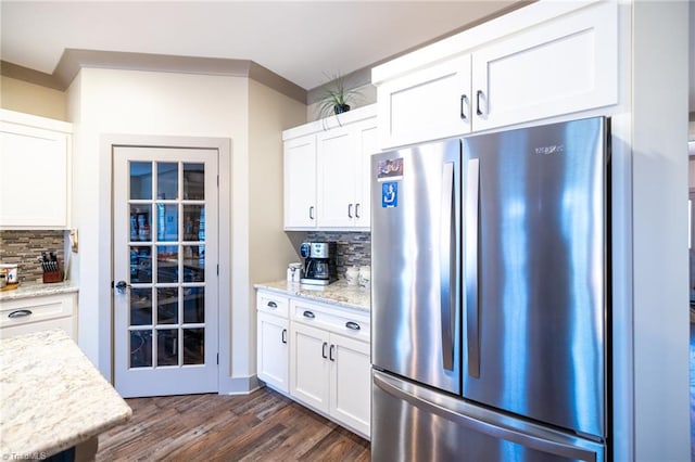 kitchen featuring white cabinets, dark wood-style floors, tasteful backsplash, and freestanding refrigerator