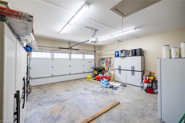 garage featuring a garage door opener and freestanding refrigerator