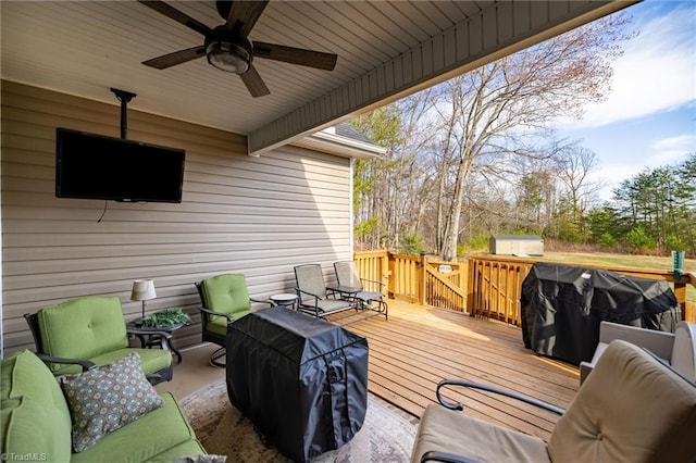 wooden terrace with a grill, an outdoor hangout area, and ceiling fan